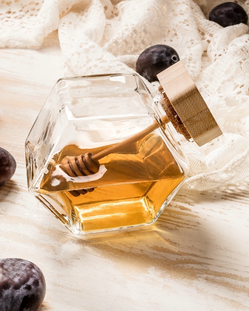 Šestiúhelníková sklenice na med s dřevěnou naběračkou
